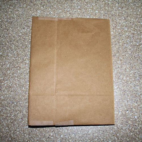 Hoe maak je een papieren zak boekomslag maken. Opengesneden een bruine papieren boodschappentas langs een naad.